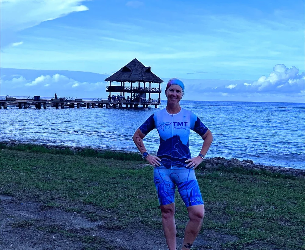 Coach Megan Tobin in a TMT Coaching kit by the water